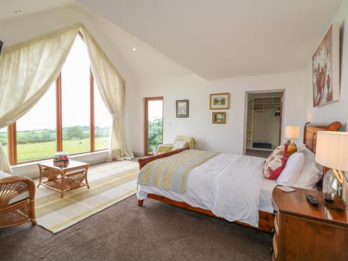 a bedroom with a bed and a large window at Millers Lane House in Aught Upper