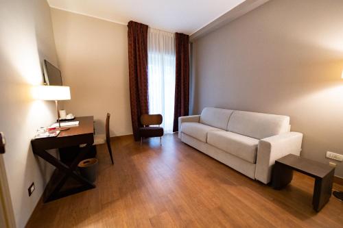 a living room with a white couch and a desk at Villa Maria Hotel & SPA in Francavilla al Mare