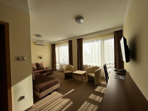 a living room with a couch and a tv at Nereus Park Hotel in Balatonalmádi