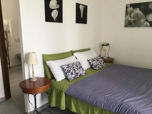 een slaapkamer met een bed met groene lakens en kussens bij Azienda Agrituristica Santissima Trinità in Budrio