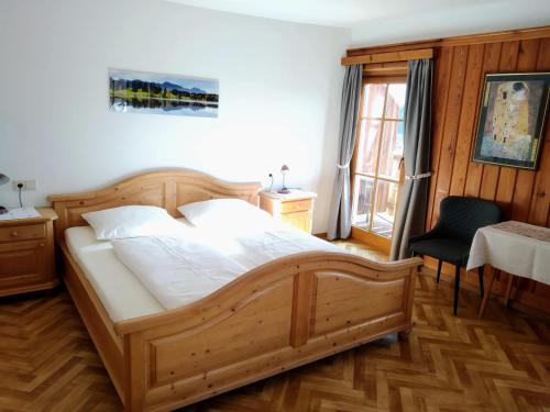 1 dormitorio con cama de madera y silla en Huberhof, en Terento