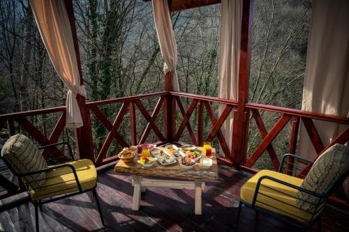 una mesa y sillas en un porche con comida. en The Canyon Kartepe and Restoran en Kartepe