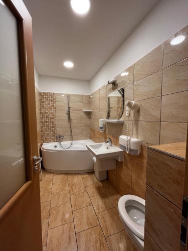 a bathroom with a tub and a sink and a toilet at Nereus Park Hotel in Balatonalmádi