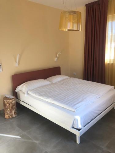 a bedroom with a large bed with white sheets at Il Cubo di Anja Home of amazing view in Pisogne