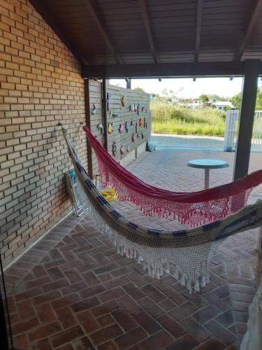 eine Hängematte, die von einer Ziegelwand in einer Terrasse hängt in der Unterkunft Casa de 3 Quartos em Garopaba - Bairro Ferraz in Garopaba