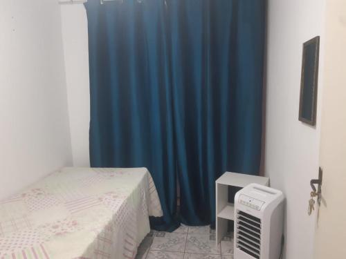 a room with a bed and a blue curtain at Pousada do Luquinhas in Brasilia