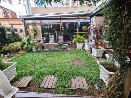 a garden with grass and wooden steps in front of a building at Hostel AJBJ Turismo in Curitiba
