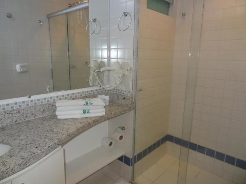 Un baño con ducha de cristal y lavabo. en Serra Park - Rio Quente Reservas, en Rio Quente