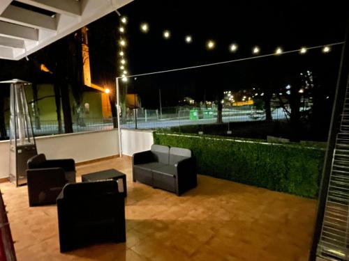un patio en la azotea con sillas y luces por la noche en La Villa, en Sala Baganza