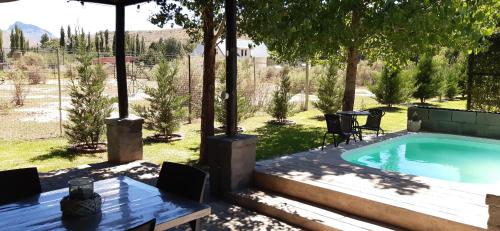 a backyard with a swimming pool and a table and chairs at Furrows Lodge in Nieu-Bethesda