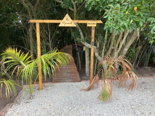 a wooden boardwalk with a sign on it with two plants at The Tsitsikamma Pyramid in Stormsrivier