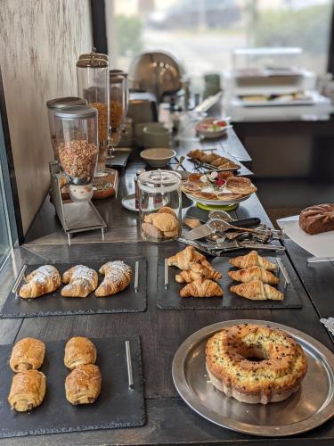 a table with various types of pastries and pies at Hotel Lis in Asti