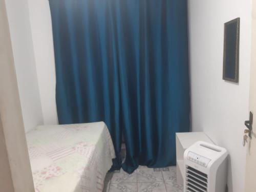 a room with a bed and a blue curtain at Pousada do Luquinhas in Brasilia