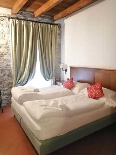 two beds in a bedroom with a window at Cascina Belvedì in Clanezzo
