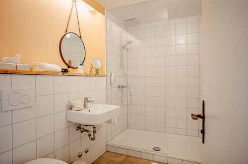 a bathroom with a sink and a toilet and a shower at Alpenrose Bayrischzell Hotel in Bayrischzell