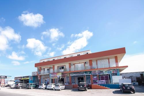 un bâtiment avec des voitures garées dans un parking dans l'établissement OYO Hotel Plaza Las Torres, Cabo San Lucas, à Cabo San Lucas
