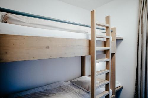 a bunk bed with a ladder in a room at Alpenrose Bayrischzell Hotel in Bayrischzell