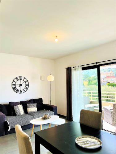 un salon avec un canapé et une table dans l'établissement Jardins de Quatrina centre ville, à Propriano