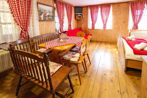 jadalnia ze stołem i kotem siedzącym na nim w obiekcie Slovenian Traditional Guest House w mieście Begunje na Gorenjskem