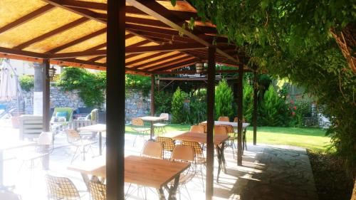 a patio with tables and chairs under a wooden umbrella at Nehir Dalyan Boutique Otel in Ortaca