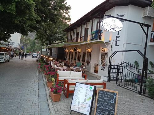 a restaurant on a city street with tables and chairs at Nehir Dalyan Boutique Otel in Ortaca