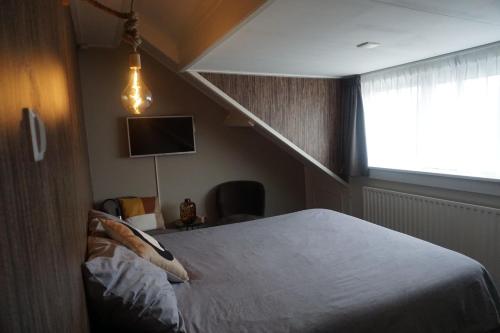 a bedroom with a large bed with a staircase at Bed and Breakfast Kik en Bun in Katwijk aan Zee
