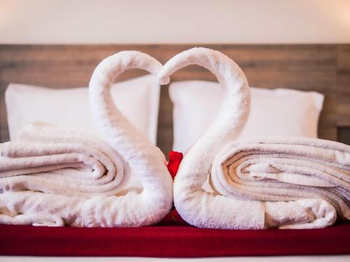 two towels shaped like swans sitting on a bed at Hotel Monotel Dar El Barka in Nouakchott