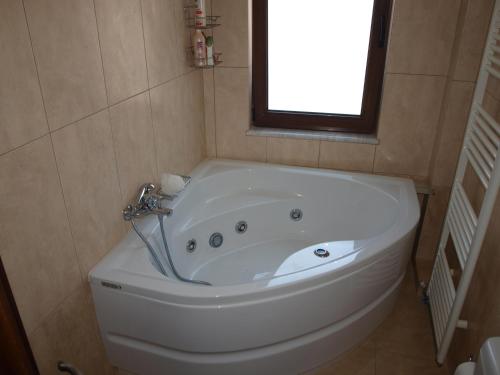 a white bath tub in a bathroom with a window at Villa Helidoni in Pondikianá