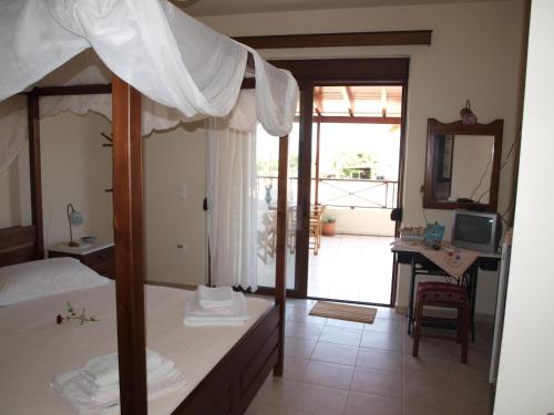 a bedroom with a bed and a desk with a mirror at Villa Helidoni in Pondikianá