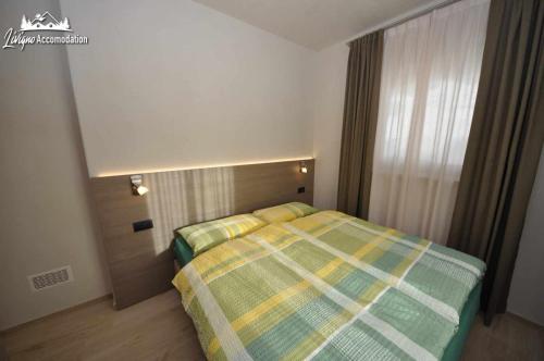 リヴィーニョにあるAl Bait da Valeriano Nuovo vicino alla latteriaのベッドルーム1室(ベッド1台、緑と黄色の毛布付)
