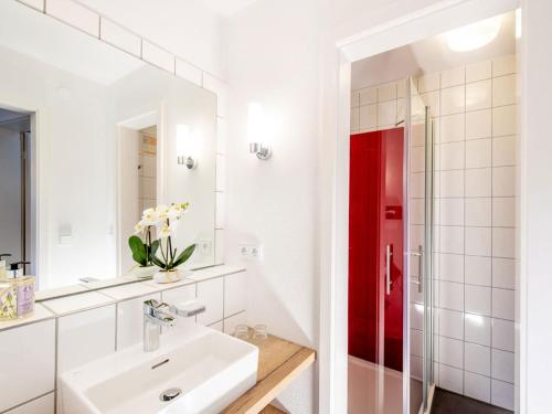 baño con lavabo y puerta roja en Hotel Busch, en Westerstede