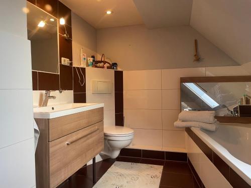 een badkamer met een toilet, een wastafel en een bad bij Tannenhaus Hohen Mistorf in Alt Sührkow