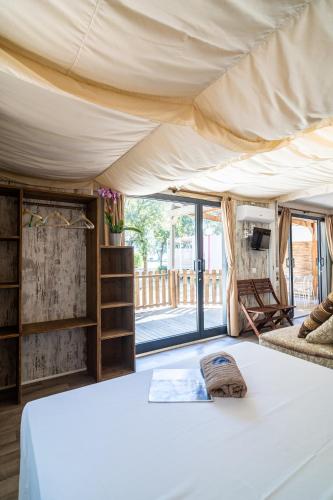 a bedroom in a tent with a bed and a window at Club del Sole Marina Julia Family Collection in Marina Julia