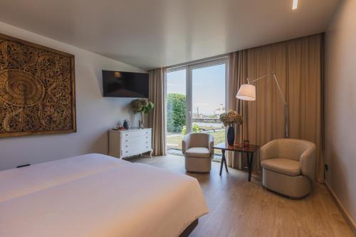 a hotel room with a bed and a desk and chairs at Quinta da Abelheira in Ponta Delgada