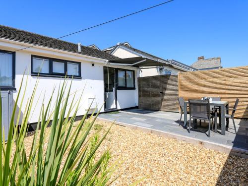 a house with a patio with a table and chairs at Little Starboard in Kingsbridge