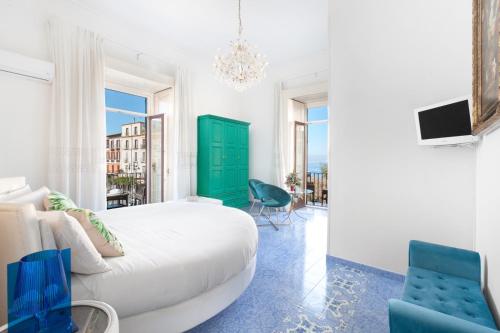 a bedroom with a white bed and a green door at Piazza Tasso B&B Relais in Sorrento