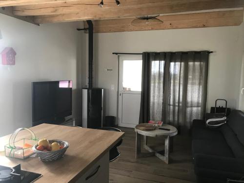 - un salon avec un canapé et une table dans l'établissement Maison au coeur d'une écurie, à Sennevières