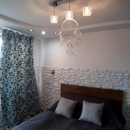 ein Schlafzimmer mit einem Bett und einer Steinmauer in der Unterkunft Apartament Hetmańska in Wałbrzych