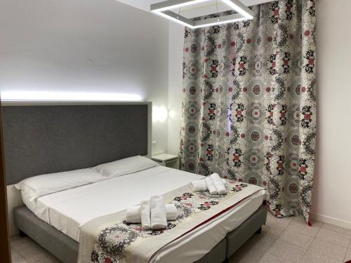 a bedroom with a bed and a curtain at Hotel Adria in Lignano Sabbiadoro