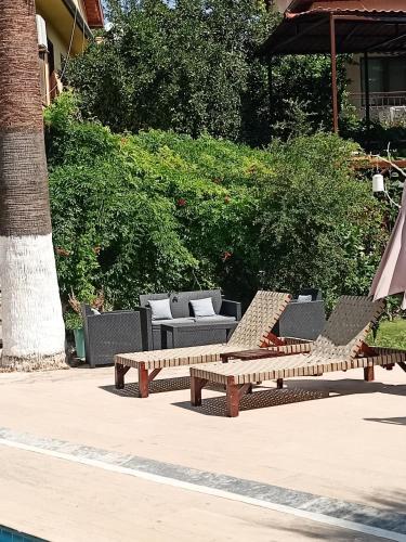 a group of benches and chairs on a patio at Nehir Dalyan Boutique Otel in Ortaca
