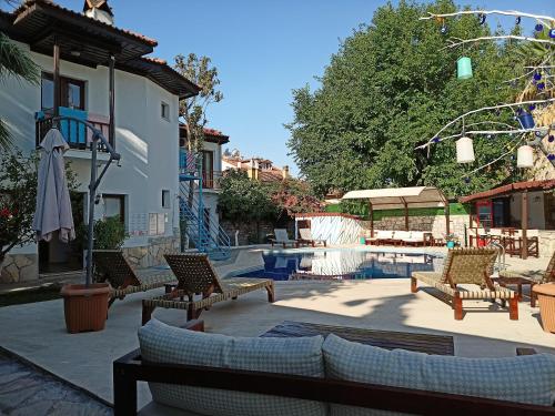 a patio with couches and chairs and a pool at Nehir Dalyan Boutique Otel in Ortaca