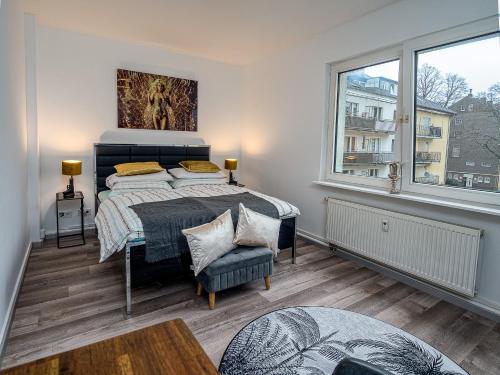 - une chambre avec un lit et une grande fenêtre dans l'établissement Exklusive und gemütliche Unterkünfte in Krefeld - JUNIK Apartments, à Krefeld