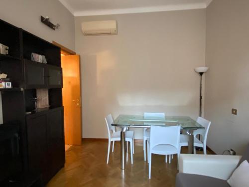 uma sala de jantar com uma mesa e cadeiras brancas em Casa Casò Guest House em Bolonha