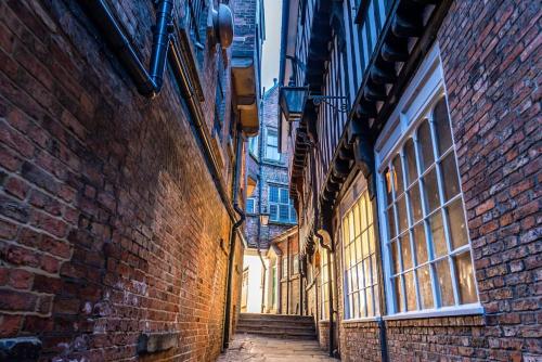 an alley way between two brick buildings with stairs at Luxury Apartment Opposite The Shambles in York