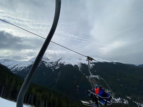 a group of people riding on a ski lift at CEDAR LODGE NEXT TO LIFT ONE BEDROOM APARTMENT in Bansko