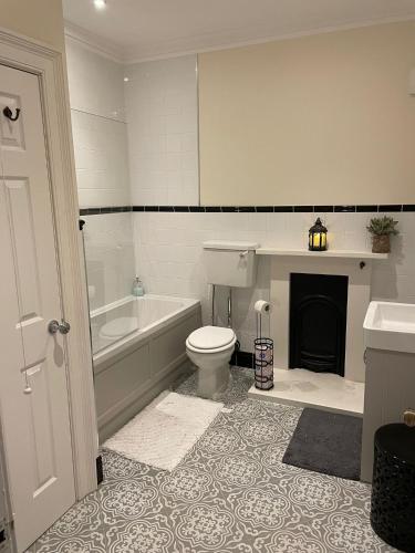 a bathroom with a tub and a toilet and a sink at Luxury Apartment Opposite The Shambles in York