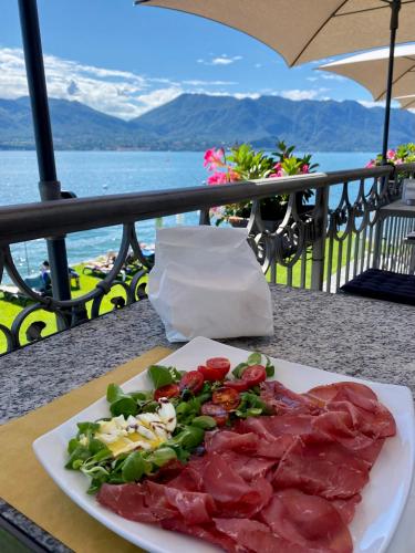 a plate of meat and vegetables on a table at Residence Casa e Vela in Oggebbio