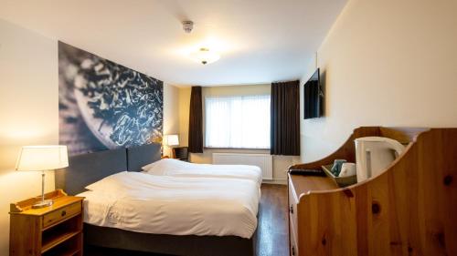 um pequeno quarto com uma cama e uma janela em Herberg de Compagnie em Enkhuizen