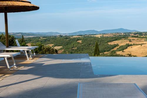 a pool with a table and an umbrella at Country House Art and Garden in Monte Antico
