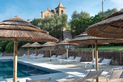a group of chairs and umbrellas next to a pool at Country House Art and Garden in Monte Antico